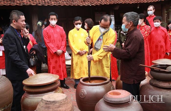 Delegates are being introduced to the craft of making soy sauce in Duong Lam ancient village